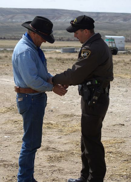 Putting on the handcuffs. Photo by Cat Urbigkit, Pinedale Online.