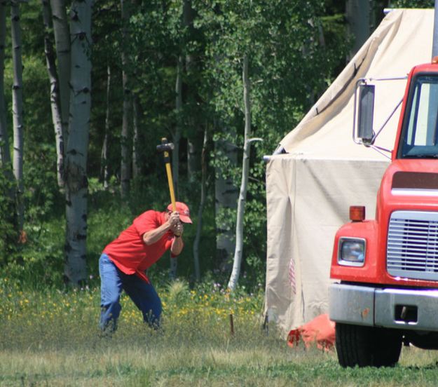 Pounding tent stake. Photo by Dawn Ballou, Pinedale Online.