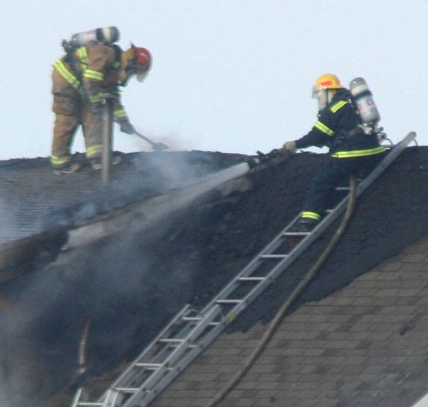 Hosing the roof. Photo by Clint Gilchrist, Pinedale Online.