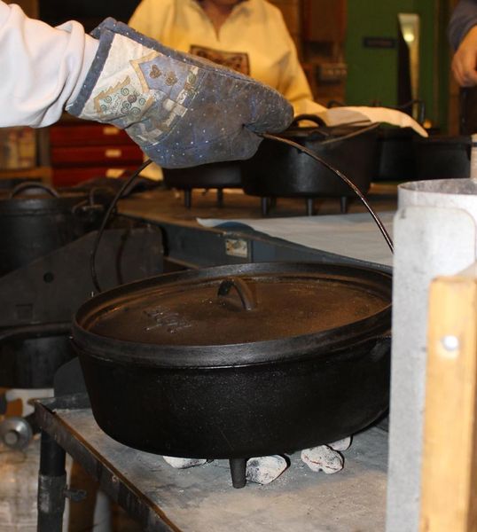 Put pot on hot coals. Photo by Dawn Ballou, Pinedale Online.