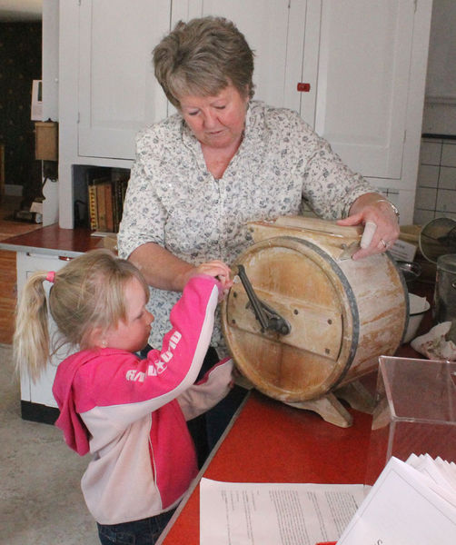 Churning butter. Photo by Clint Gilchrist, Pinedale Online.