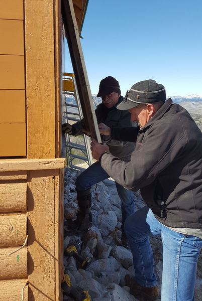 Putting on the shutters. Photo by Sublette County Historic Preservation Board.