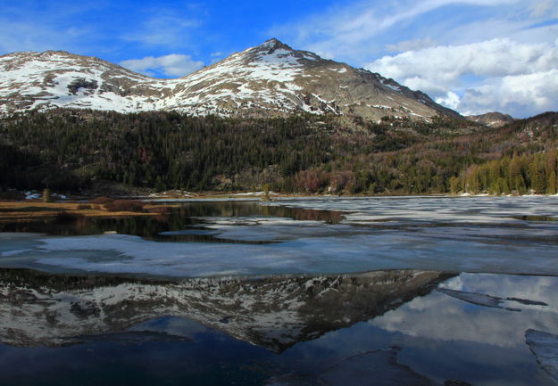 Big Sandy Mtn. reflected in ice breakup on Big Sandy Lk.. Photo by Fred Pflughoft.