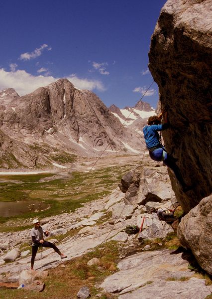 Sue top-roping an overhanging boulder problem in Titcomb Basin belayed by our friend J.H. Gaines / Wind River Mtns. / circa 1989 / by the way Sue was the only one to complete it!. Photo by Fred Pflughoft.