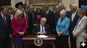 Signing the bill. Photo by White House.